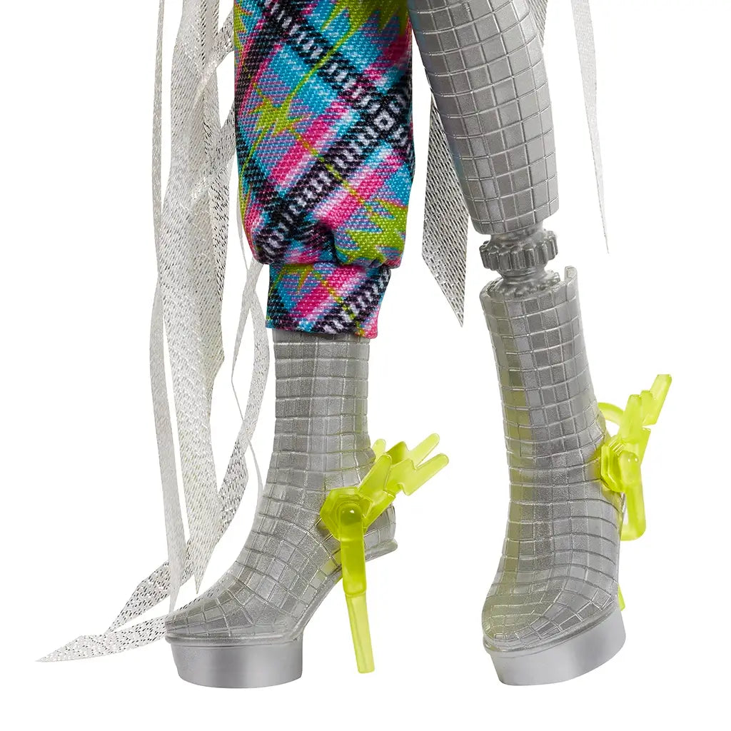 Close-up of Monster High Frankie Stein doll’s silver textured platform boots with neon yellow lightning bolt clips and metallic grid-like detailing.
