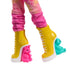 Close-up of Monster High Enid Sinclair doll’s yellow lace-up boots featuring sculpted pink unicorn and teal bear heels, paired with patterned pink leggings for a playful look.