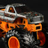 Close-up of Monster Jam Bad Company 1:64 monster truck, emphasizing detailed skull and flame graphics, orange suspension frame, and aggressive treaded wheels.