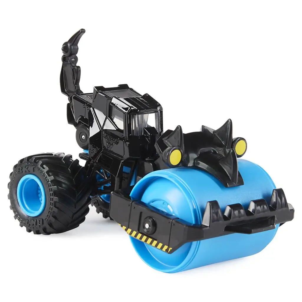 Monster Jam Rolland paver truck in black and bright blue plastic with smooth roller drum and claw-like front detail, compact vehicle form on oversized rubber tires, shown on a clean white studio background.