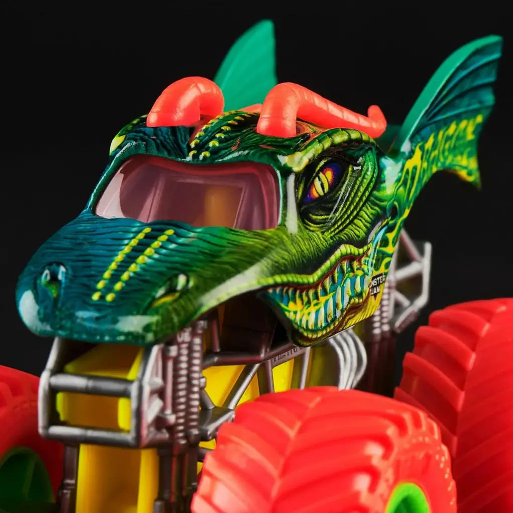 Closeup of Monster Jam Dragon 1:64 scale diecast truck, showing green dragon face design with yellow accents, red horns, sharp teeth, and oversized neon red wheels.