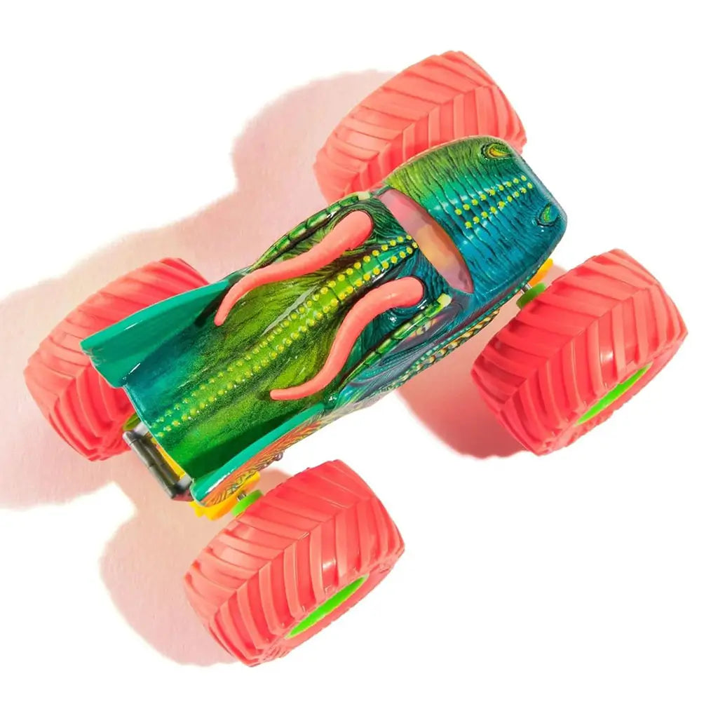 Top view of Monster Jam Dragon diecast truck 1:64 scale, showing green scaled body, red horns, yellow highlights, and large neon red wheels with green hubs.