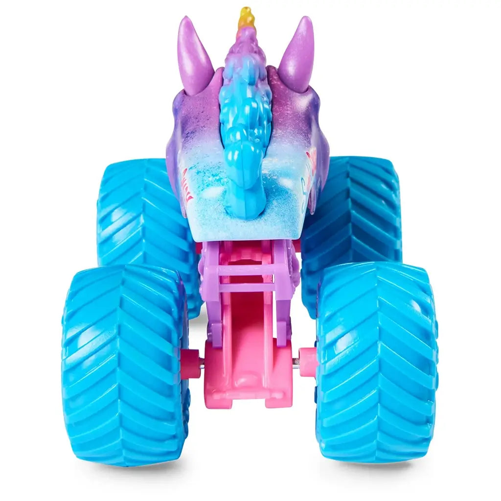 Monster Jam Sparkle Smash truck rear view in purple, pink, and blue plastic with unicorn horn and tail details and chunky blue wheels designed for play on a plain backdrop.
