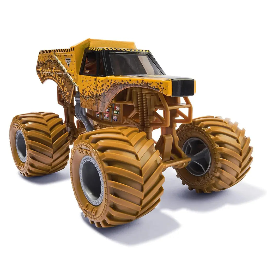 Monster Jam Earth Shaker 1:24 scale diecast truck features bright yellow cracked stone graphics, oversized treaded brown wheels, and realistic suspension detail for display or play.