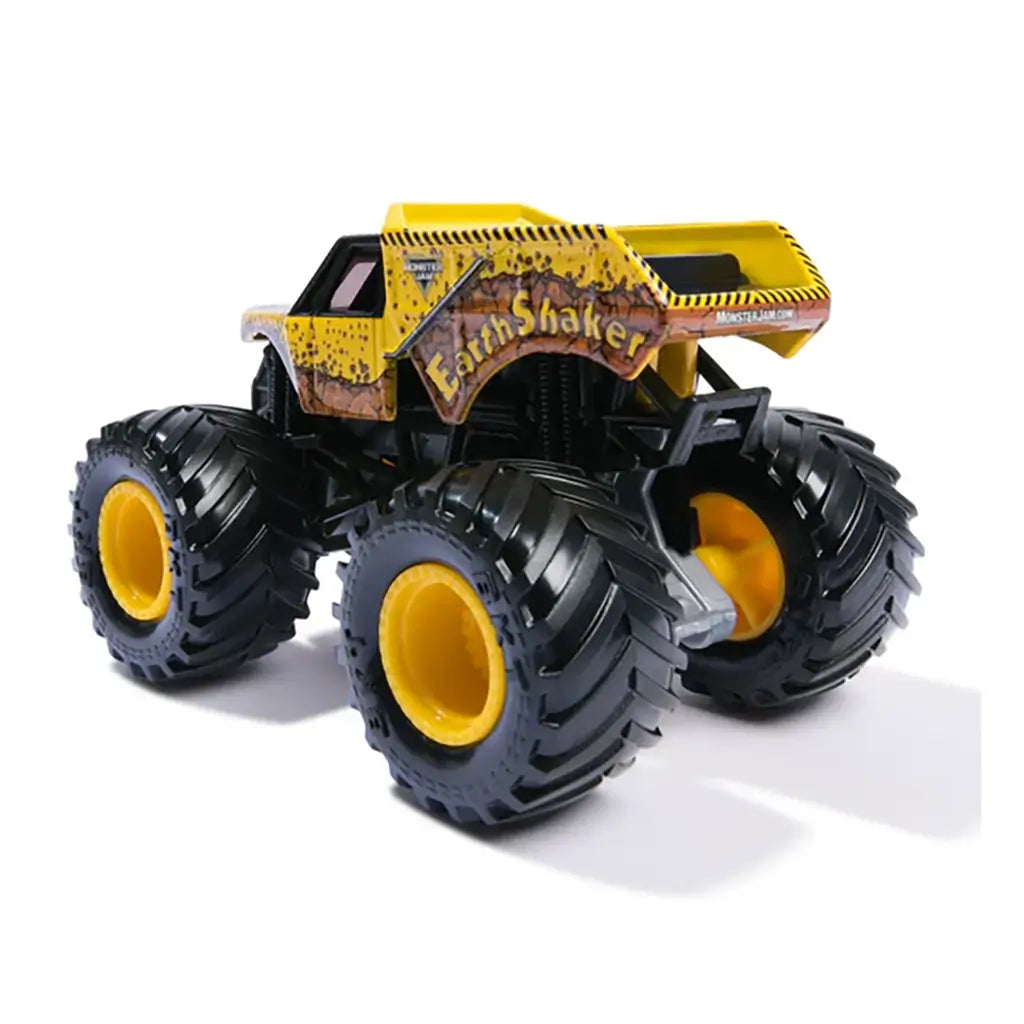 Monster Jam Earth Shaker toy truck in yellow with rugged dirt-splatter design, oversized black tread tires, and bold Earth Shaker logo, displayed on white background.