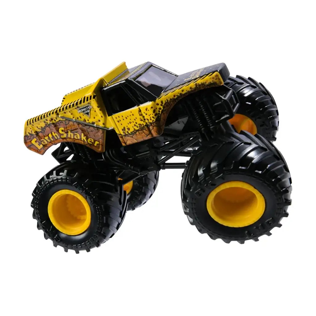 Yellow Monster Jam Earth Shaker monster truck toy with realistic dirt details, massive deep-groove black wheels, and bold side graphics, set against plain white backdrop.