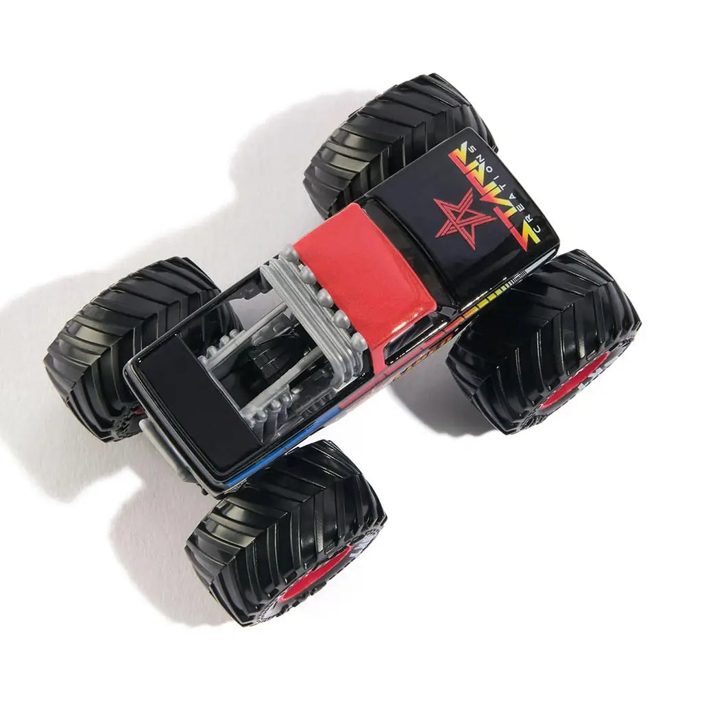 Top view of Monster Jam Excaliber diecast monster truck, showing red roof, rainbow side stripes, black hood with logo, and four oversized black tires.