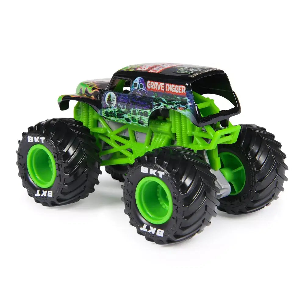 Monster Jam Grave Digger toy truck in black and green painted body with flame and skull graphics, rugged plastic chassis and oversized rubber tires with deep treads and green rims, shown from a rear angled view on a white background.