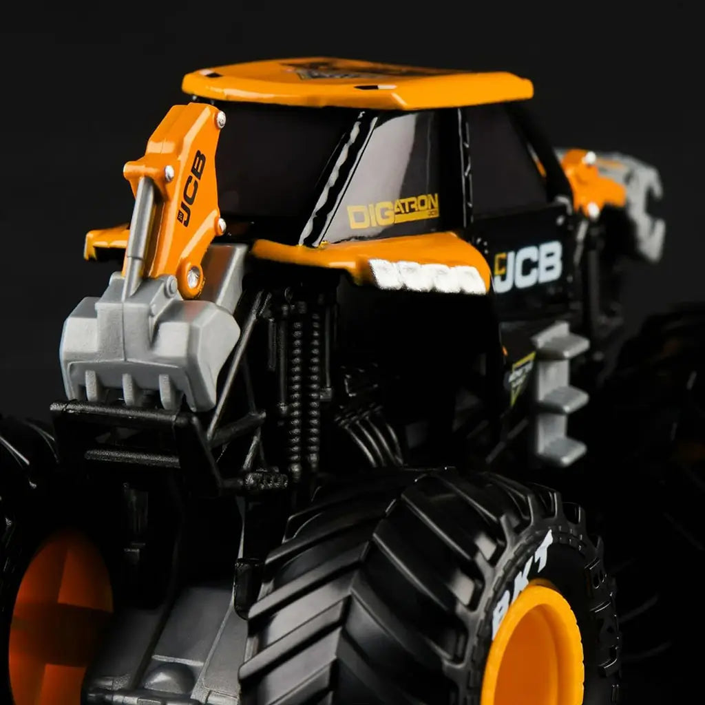 Closeup of Monster Jam JCB Digatron 1:64 scale diecast truck, highlighting orange cab, JCB logos, rugged tread tires, and gray mechanical details at the front.