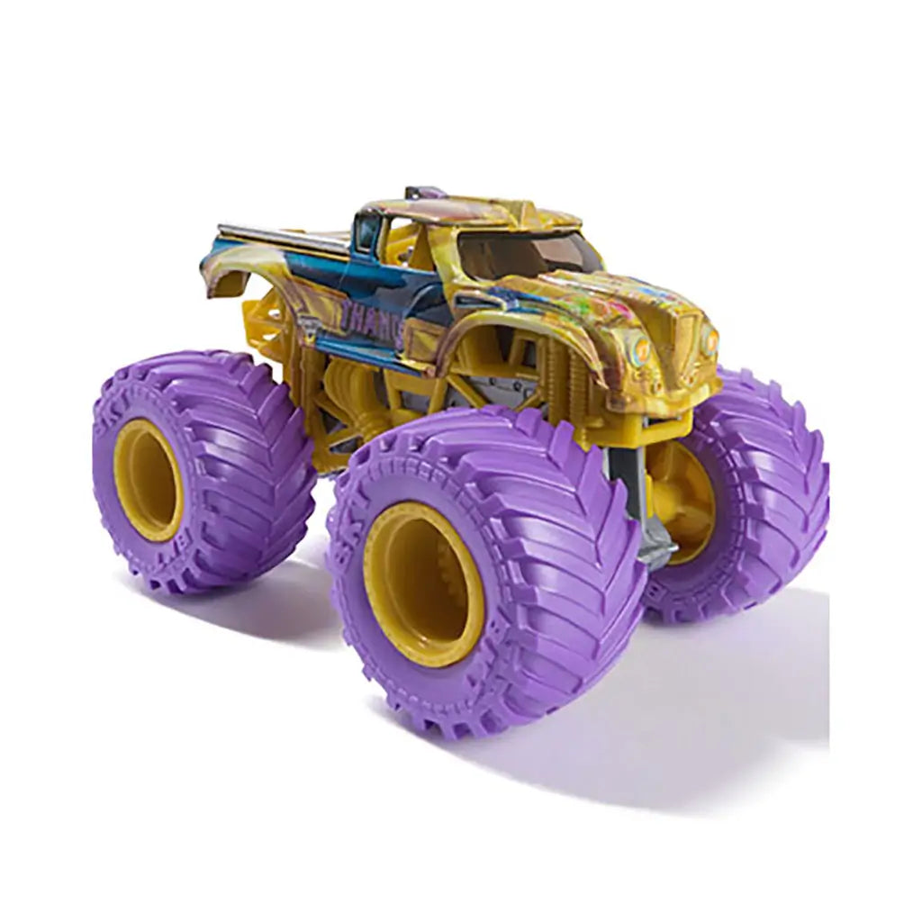Close-up of Marvel Monster Jam Thanos toy truck with gold body, detailed textures, blue side accents, and oversized rugged purple tires displayed against a plain white background.