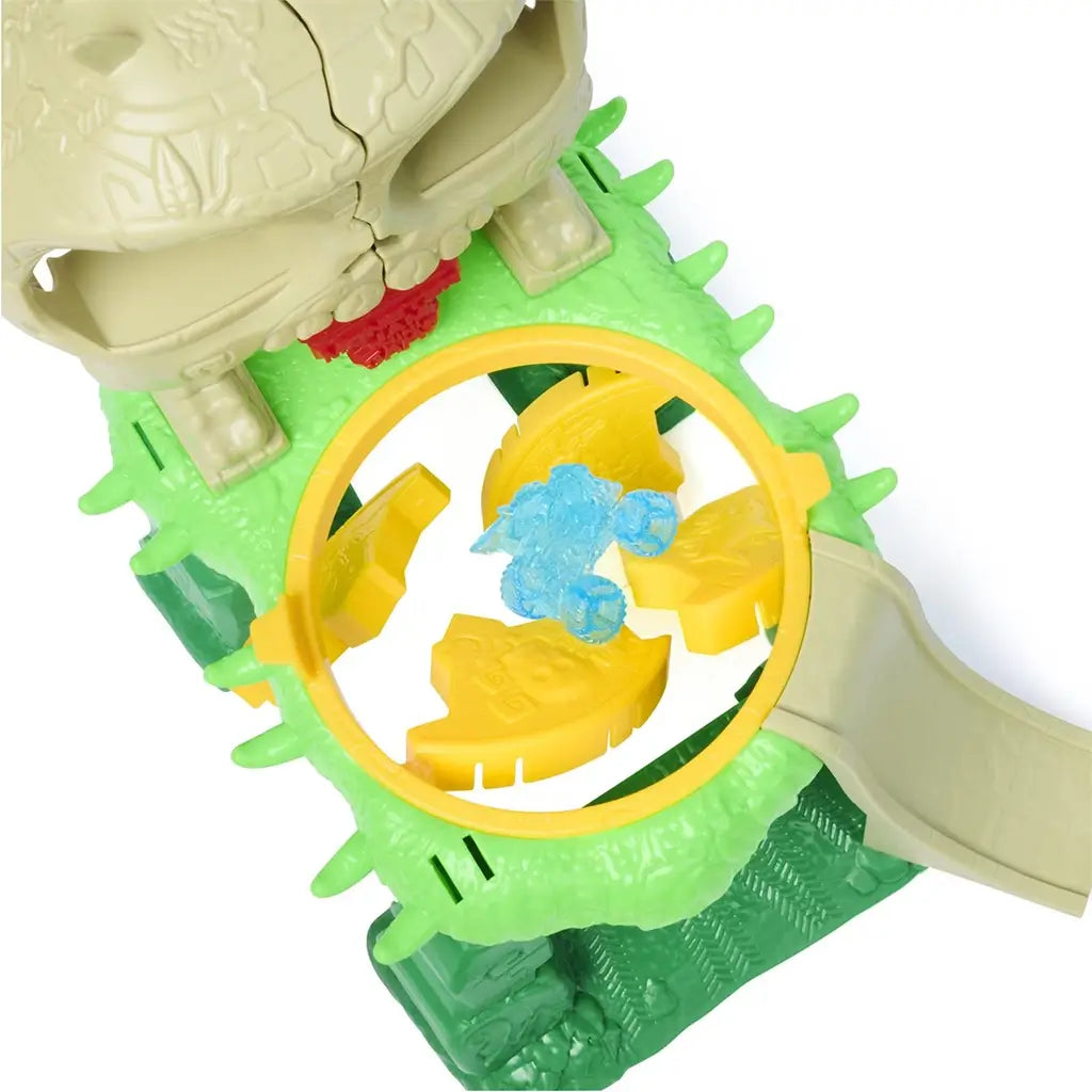 Monster Jam Crash ’n Crumble Jungle playset close-up showing green plastic jungle ring with yellow break-apart panels and translucent blue mini truck, highlighting interactive crumble feature and circular stunt arena design.