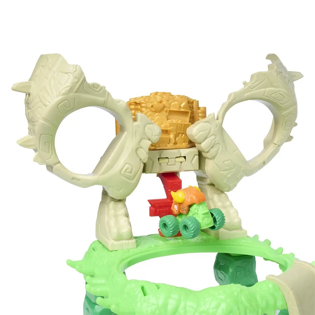 Monster Jam Mini Jams jungle launcher accessory in green plastic with yellow lever, shown beside skull-themed playset to demonstrate truck launching feature that sends mini monster trucks into the crumble arena.