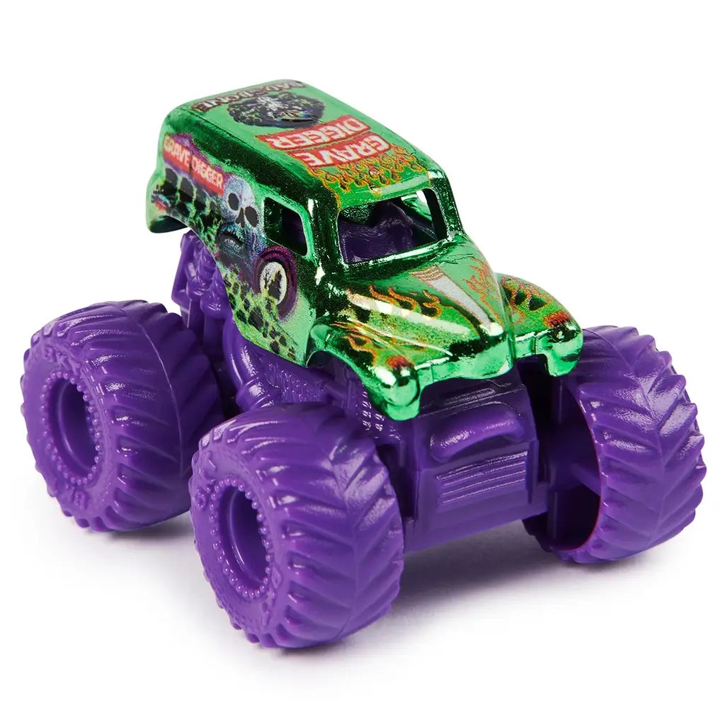 Monster Jam Grave Digger mini truck in metallic green die-cast body with skull graphics and flame decals, compact van shape on oversized purple rubber tires, displayed on a clean white studio background.