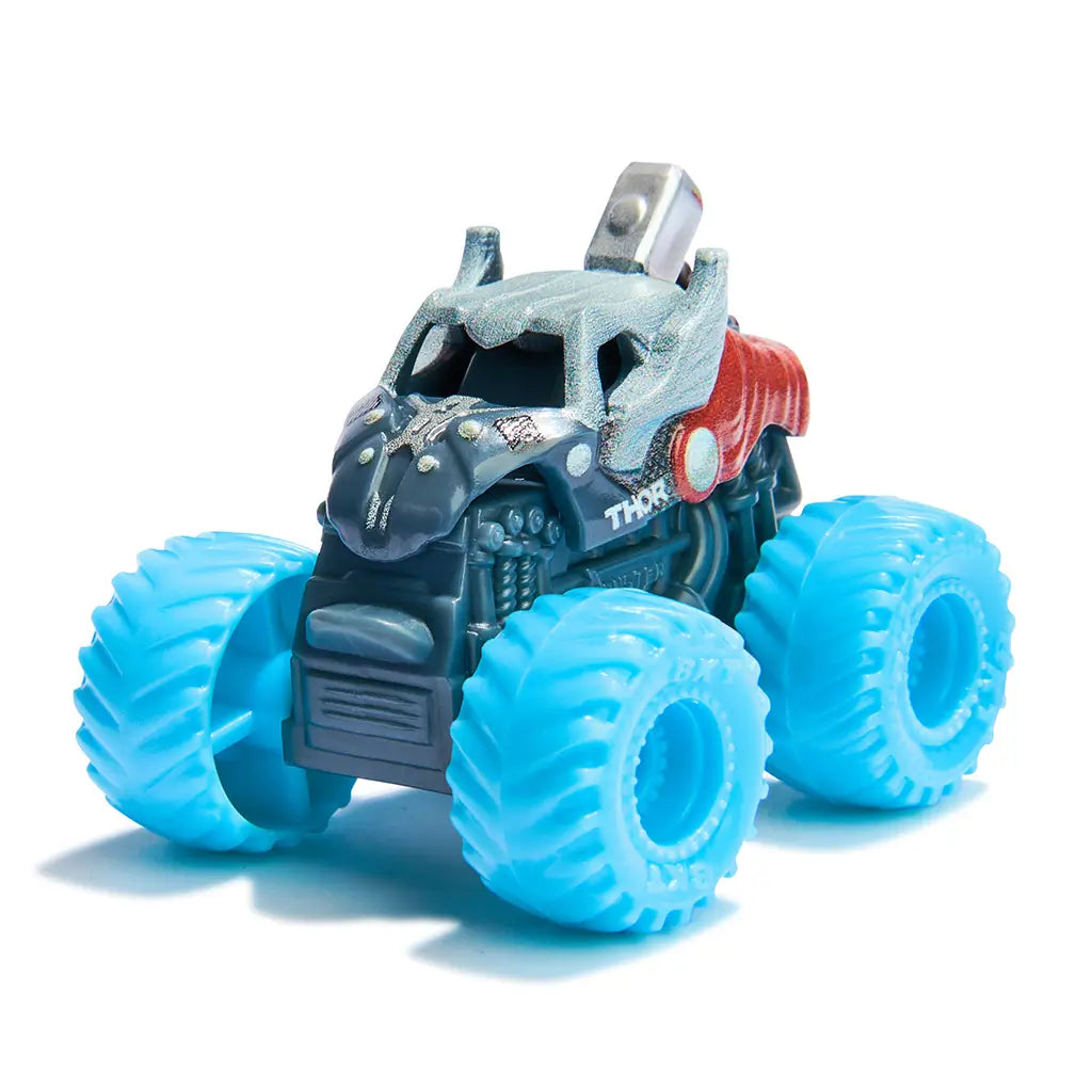 Monster Jam Thor mini truck in gray and red plastic with metallic hammer detail, large light blue textured wheels, compact monster truck toy form for play, placed on a bright white studio background.