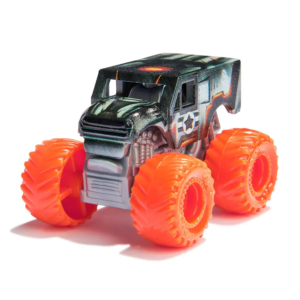 Monster Jam War Machine mini truck in black and gray metallic plastic with orange wheels, rugged oversized tire design, compact monster truck shape for play, set against a bright white studio backdrop.