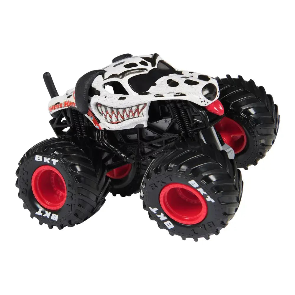 Monster Jam Monster Mutt Dalmatian toy truck in white and black spotted metal body with textured dog face design, oversized rubber tires and red wheel rims, isolated on a white background.