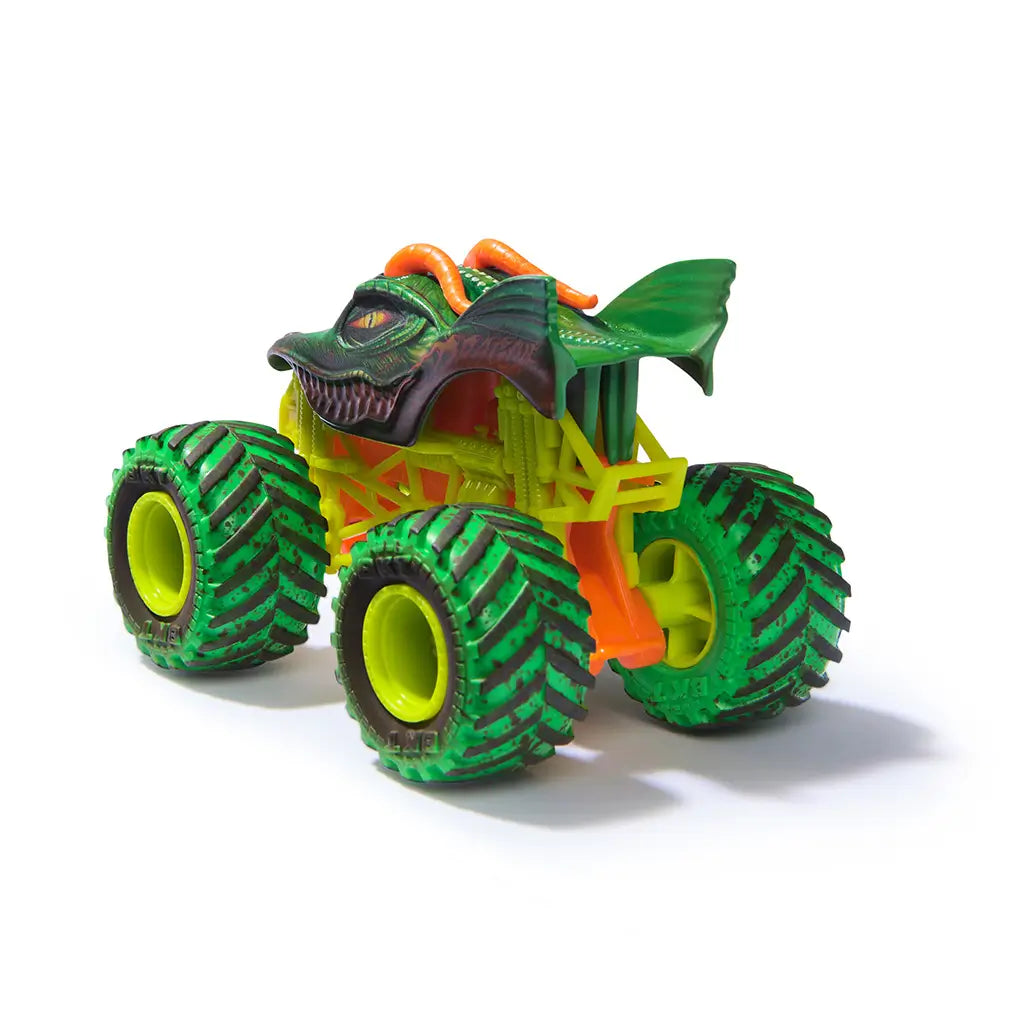 Monster Jam Dragon toy truck in green and orange plastic with scaly texture and winged body shape, oversized treaded tires, rear angled view highlighting detailed chassis and rugged monster truck design on white background