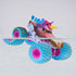 Monster Jam Sparkle Smash toy truck in pink, blue, and brown plastic with mud texture, teal tires and pink rims, partially submerged in water to demonstrate color change feature, set against a clean minimal background