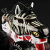 Close-up of Monster Jam Racing Stripes 1:64 diecast truck, styled like a zebra with black stripes, pointed ears, fierce yellow eyes, and bold white frame.