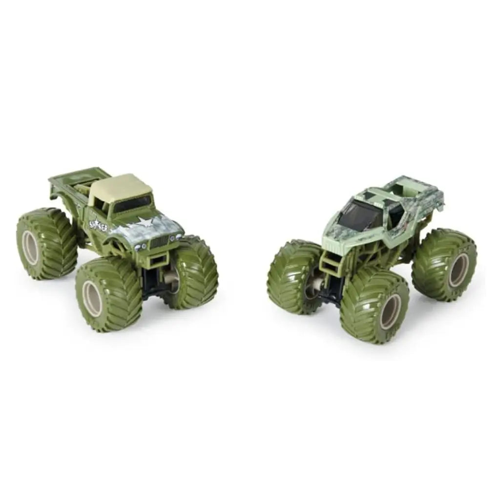 Side-by-side Monster Jam Shaker and Soldier Fortune 1:64 scale toy trucks, both in army green with massive textured wheels, rugged detailing, and bold military-style designs.
