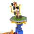 Monster Jam playset featuring a yellow and gray plastic trampoline platform atop a blue tower, launching a red and yellow monster truck upward for jumping stunts on a classroom crash course setup.