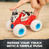 Monster Jam Monster Mutt Dalmatian toy truck red plastic body with white and black spotted dog-themed shell and blue wheels, shown being pressed to repair after crash on a wooden tabletop background