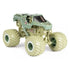 Angled view of Monster Jam Soldier Fortune diecast truck highlights desert camo paint, black tinted cab, rugged suspension, and giant beige wheels with deep tread for off-road play.