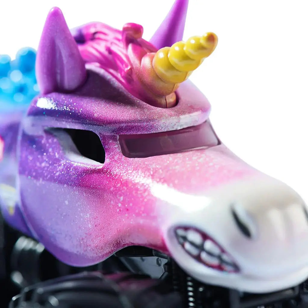 Monster Jam Sparkle Smash Legacy 1:64 scale monster truck close-up of unicorn face featuring golden horn, purple ears, white snout with teeth, and shimmering paint details.