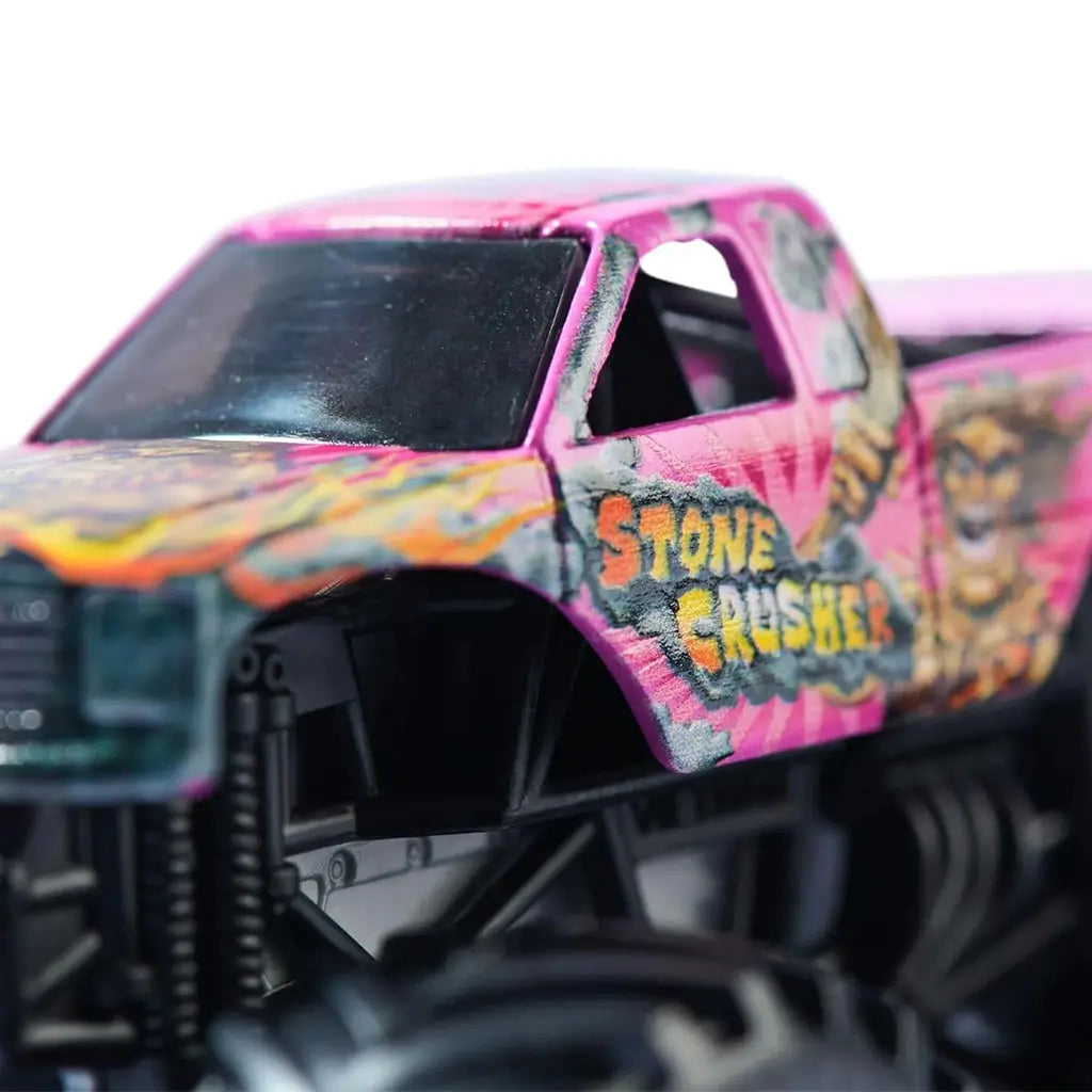 Closeup of Monster Jam Stone Crusher toy truck in pink with fiery yellow-orange graphics, bold 'Stone Crusher' logo, rugged details, and oversized black tires for dramatic off-road style.