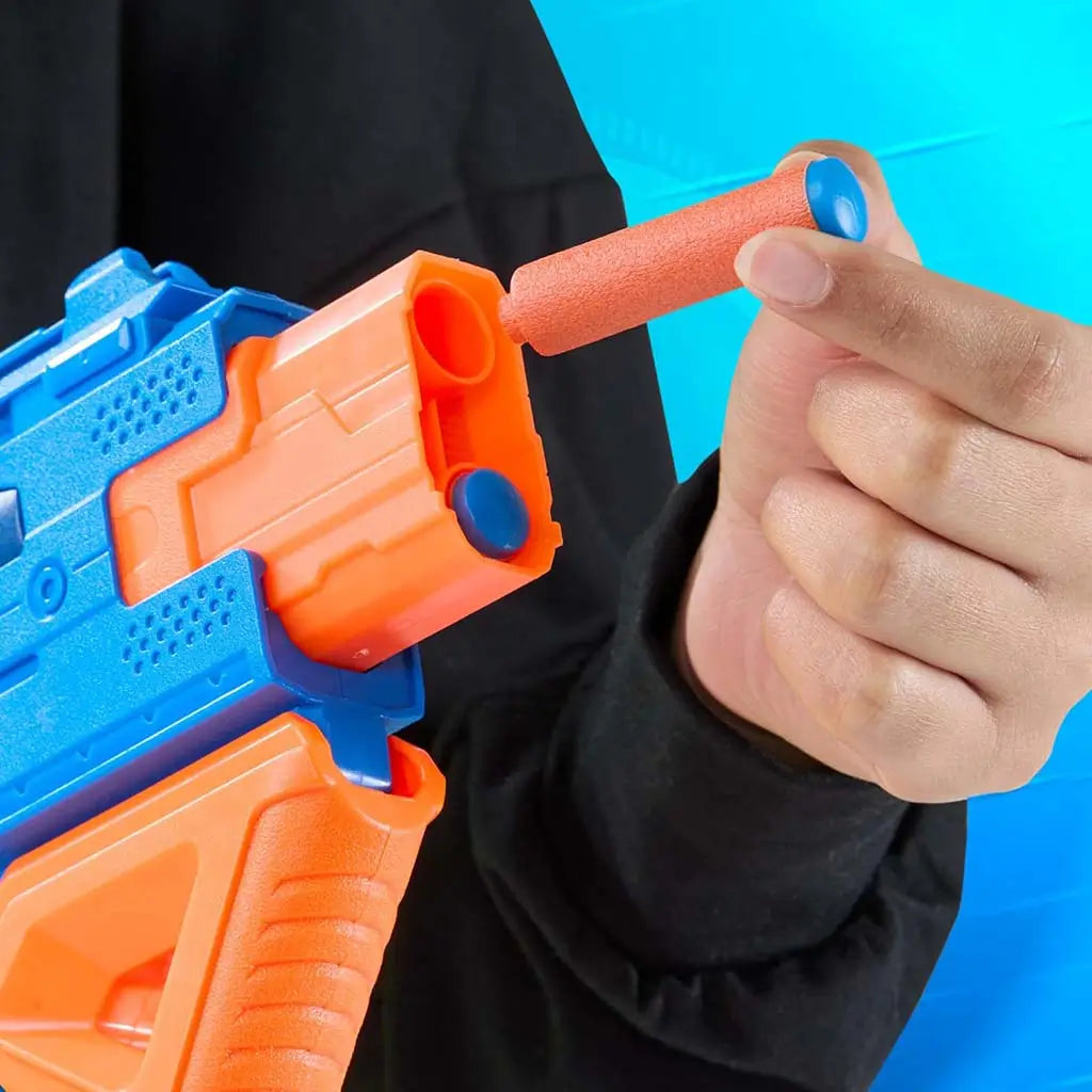 Close-up view of the Nerf N-Series Double Impact blaster showing a hand loading an orange foam dart with a blue tip into the front barrel, highlighting the smooth plastic build and easy-load design.