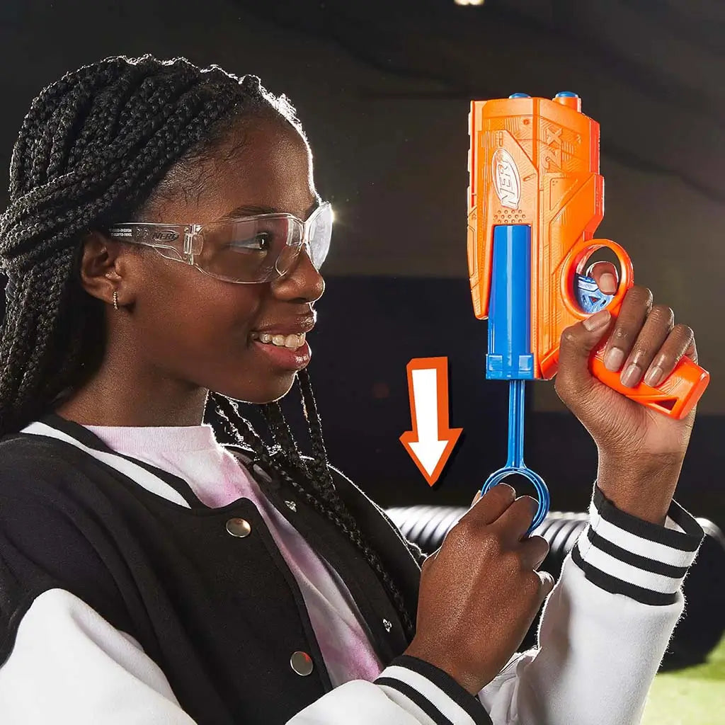 NERF pull-back priming blaster shows bright orange and blue plastic parts with ring-shaped handle extended as a child draws it downward, demonstrating simple operation in an indoor play setting. Described in clear detail for accessibility and user understanding.