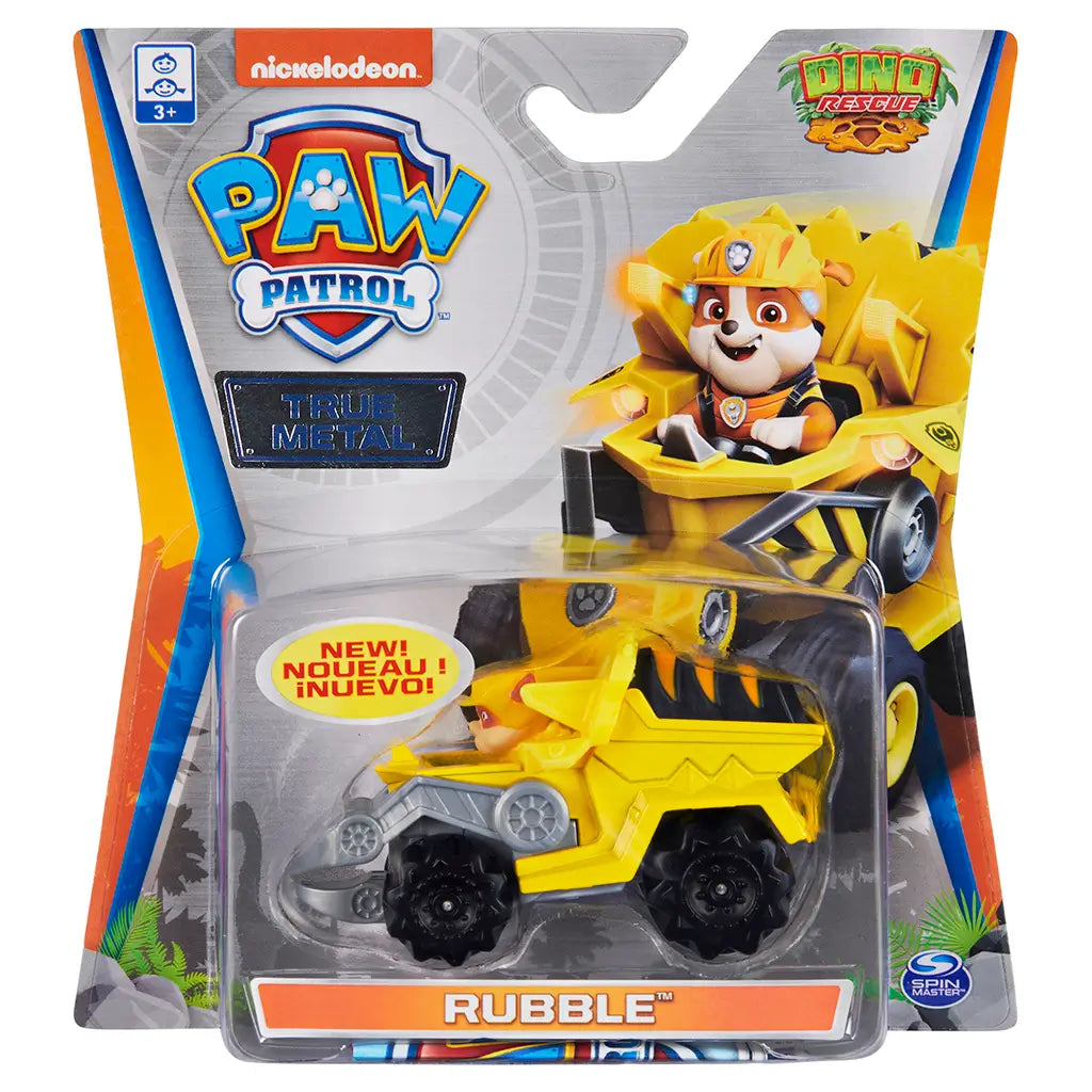 PAW Patrol Rubble Dino Rescue toy yellow die cast metal truck with black textured wheels and gray scoop, shown in retail packaging with Nickelodeon branding and colorful jungle themed background.