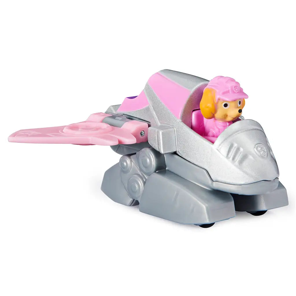 Paw Patrol Skye Dino Rescue die-cast toy car in pink and silver plastic and metal finish, compact winged jet vehicle shape with character driver, angled view on a plain white studio background.