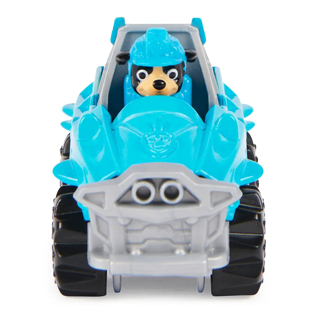 Blue die-cast Paw Patrol Rex Dino Rescue truck with gray grille, molded bumper, and visible character driver, compact off-road vehicle front view displayed against a plain white background.