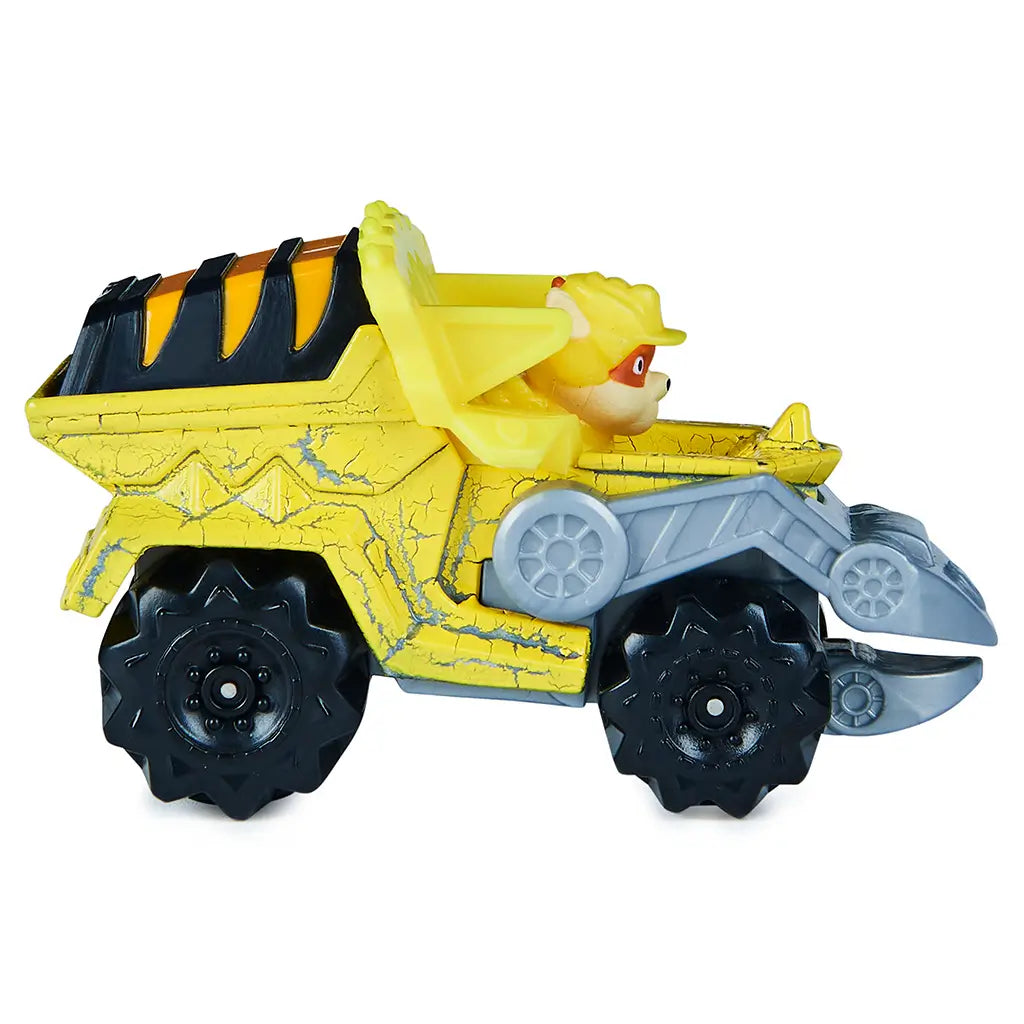 Paw Patrol Rubble toy truck side view in bright yellow die-cast metal and plastic, long angular dump truck form with black wheels and gray articulated scoop, suited for imaginative construction play on white background