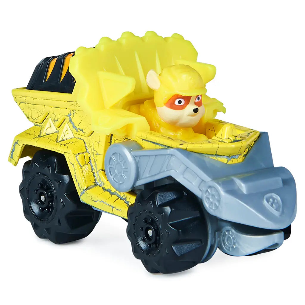 Paw Patrol Rubble toy truck in bright yellow die-cast metal and plastic, chunky angular dump truck form with black wheels and gray scoop arm, designed for construction play on a clean white background