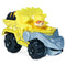 Paw Patrol Rubble toy truck in bright yellow die-cast metal and plastic, chunky angular dump truck form with black wheels and gray scoop arm, designed for construction play on a clean white background