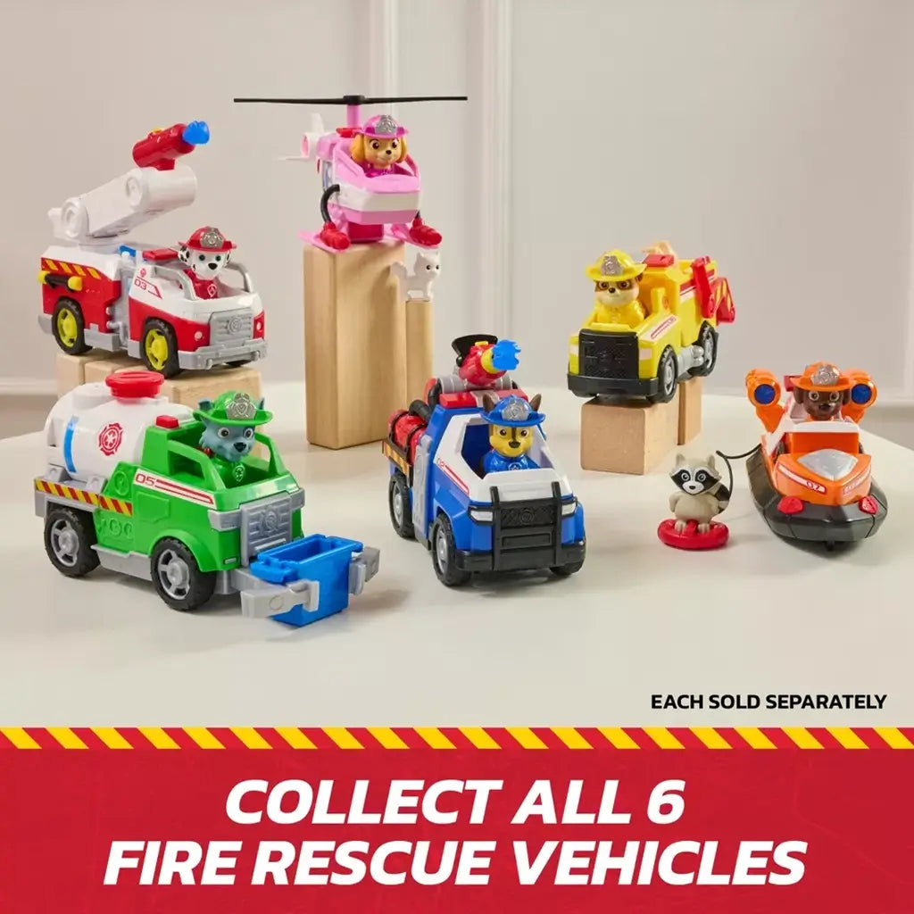 PAW Patrol fire rescue vehicles collection in multicolor plastic with character figures in helmets, arranged on wooden blocks to showcase themed trucks and helicopter against a light indoor backdrop.