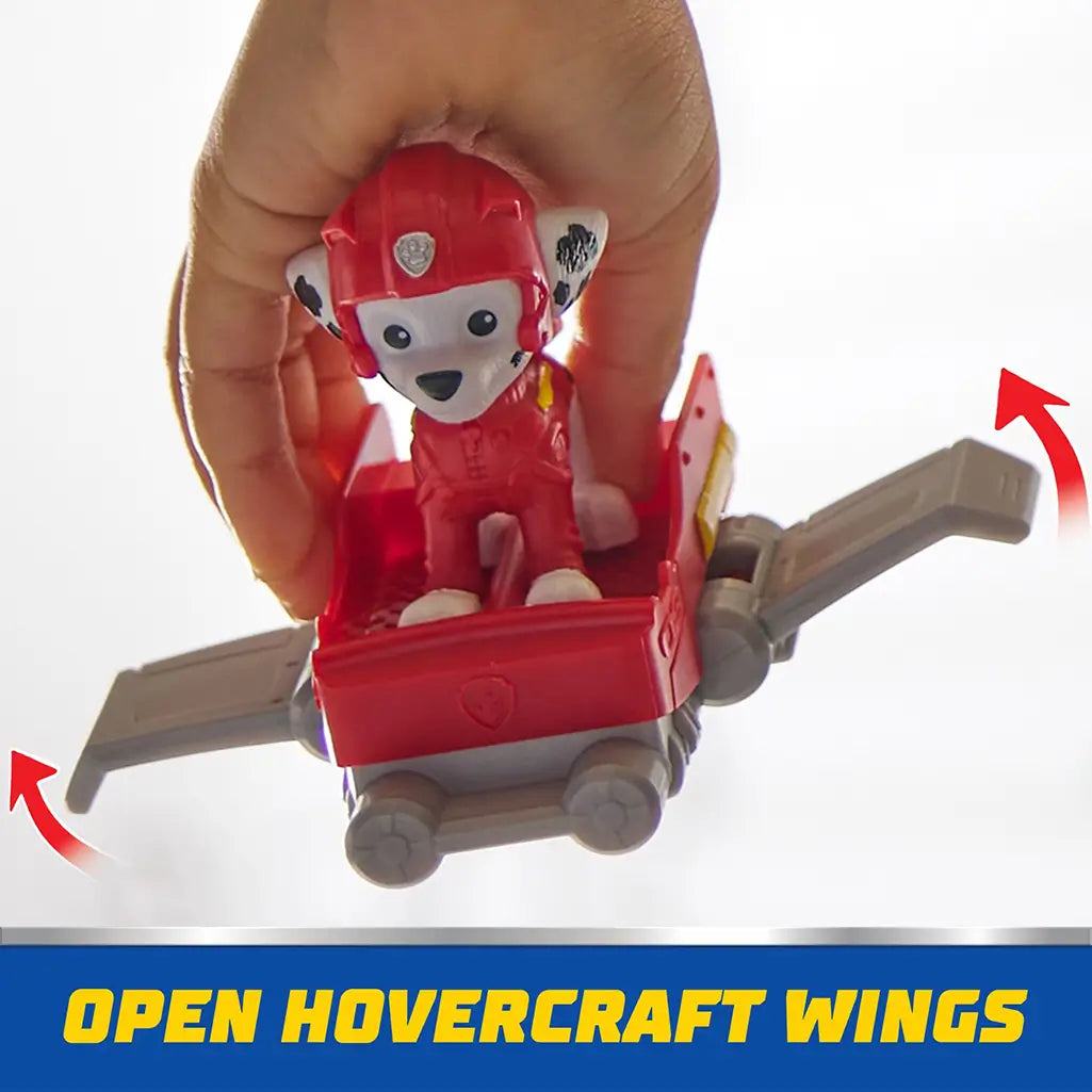 Hand holds PAW Patrol Marshall figure riding red hoverboard with gray wings extended, showcasing interactive hovercraft wing feature for action-packed play.