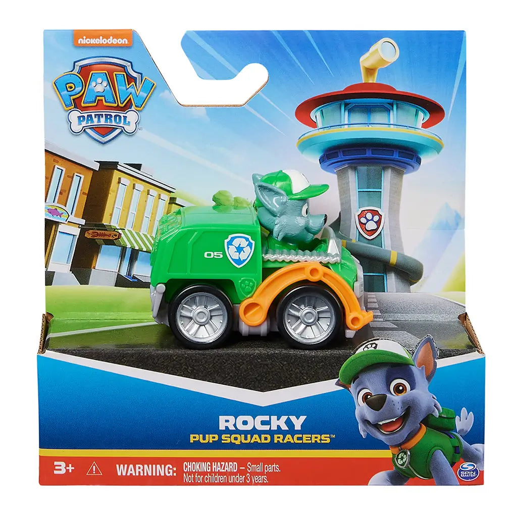 Paw Patrol Rocky Pup Squad Racers toy in green plastic recycling truck with silver wheels and gray pup figure, packaged in colorful Nickelodeon retail box, displayed against illustrated Adventure Bay backdrop for retail shelf presentation