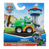 Paw Patrol Rocky Pup Squad Racers toy in green plastic recycling truck with silver wheels and gray pup figure, packaged in colorful Nickelodeon retail box, displayed against illustrated Adventure Bay backdrop for retail shelf presentation