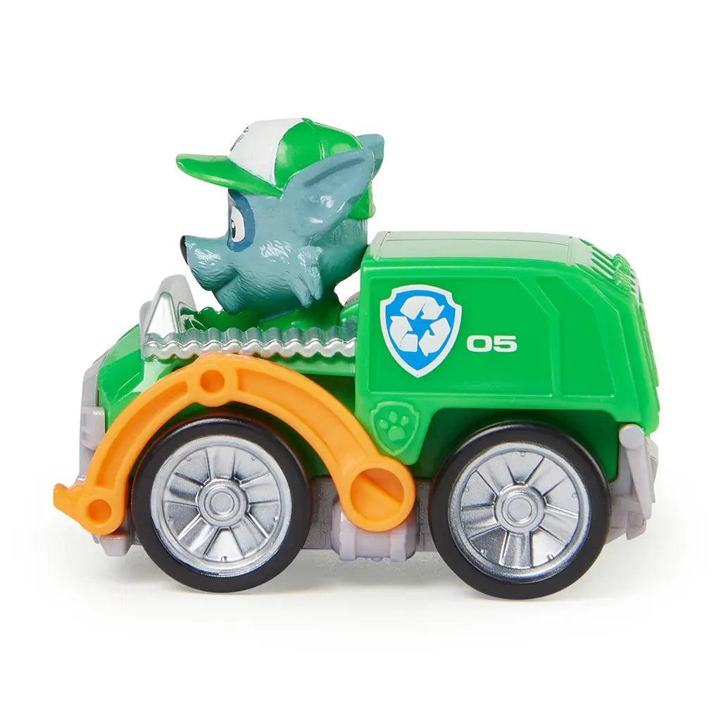 Paw Patrol Rocky vehicle toy in green molded plastic with silver wheels and orange side arms, side profile showing compact recycling truck racer form with eco-themed details, isolated on a clean white background for product display