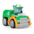 Paw Patrol Rocky racer toy in green plastic with glossy finish, silver wheels, and gray pup character wearing green cap, angled three-quarter view highlighting compact recycling design, isolated on a white studio background