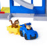 PAW Patrol Pup Squad police car toy in blue plastic with black wheels and yellow trailer, small animal figure riding inside, rescue vehicle accessory set displayed on a clean white background.