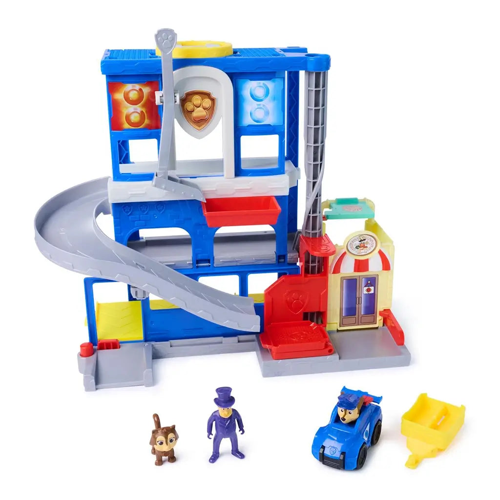 PAW Patrol Pup Squad Search and Rescue HQ playset in blue and gray plastic with red ramp and elevator, complete rescue station set shown with figures, vehicle and accessories arranged on a white background.