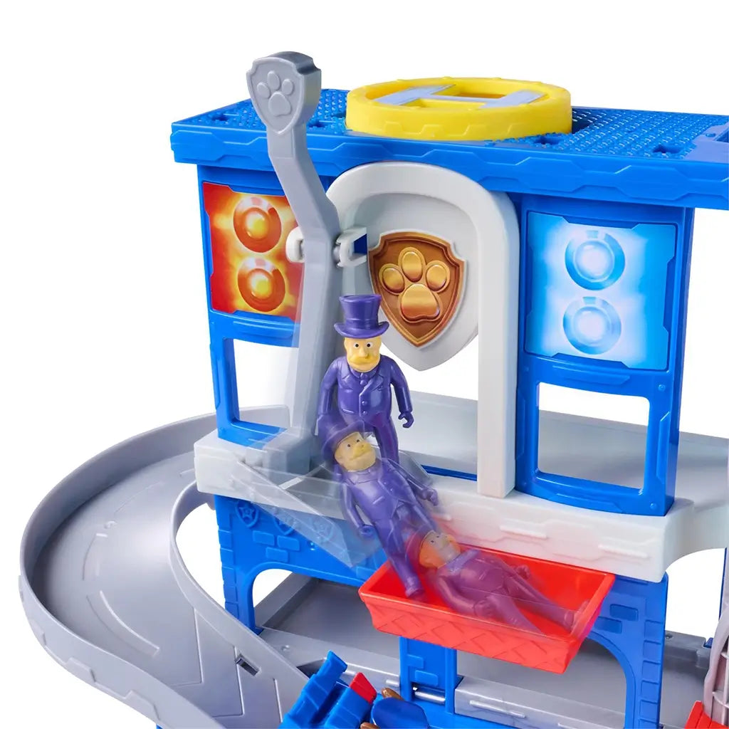 PAW Patrol Pup Squad Search and Rescue HQ playset in blue and gray plastic with red rotating elevator arm and slide platform, action feature demonstrated with character figure inside rescue tower on a white background.