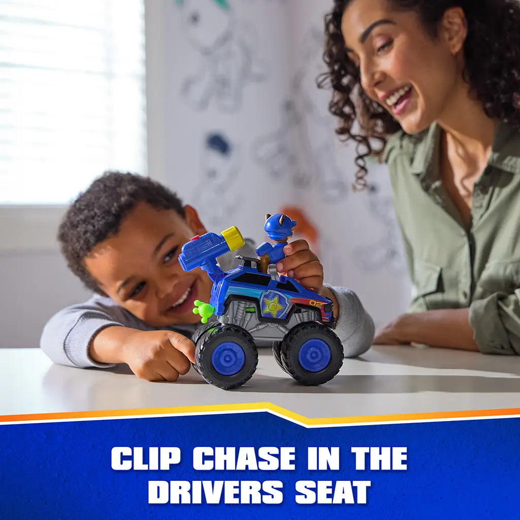 PAW Patrol toy truck blue plastic monster vehicle with black rubber wheels and yellow launcher, featuring Chase figure seated in driver area, used by child at table in bright playroom setting.