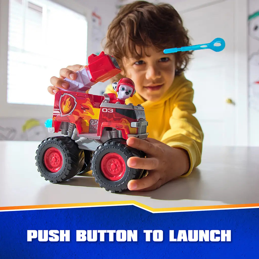 PAW Patrol Marshall fire truck toy includes bright red plastic body with smooth texture, ladder launcher and projectile feature, oversized wheels, shown in child’s hands during engaging tabletop play in a bright room.
