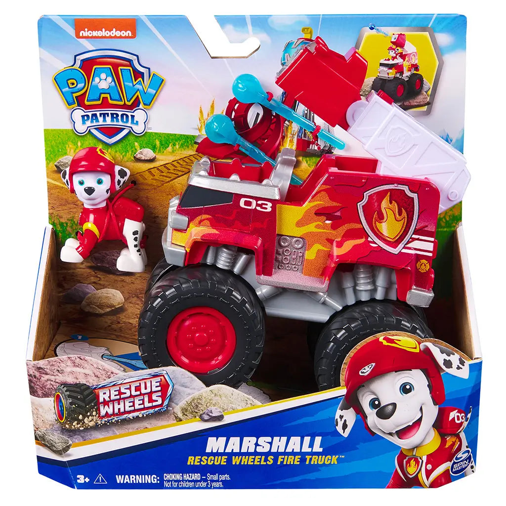 PAW Patrol Marshall Rescue Wheels fire truck in retail packaging features bright red plastic vehicle with flame graphics, oversized wheels, and character figure, presented in colorful branded box with outdoor scene backdrop.