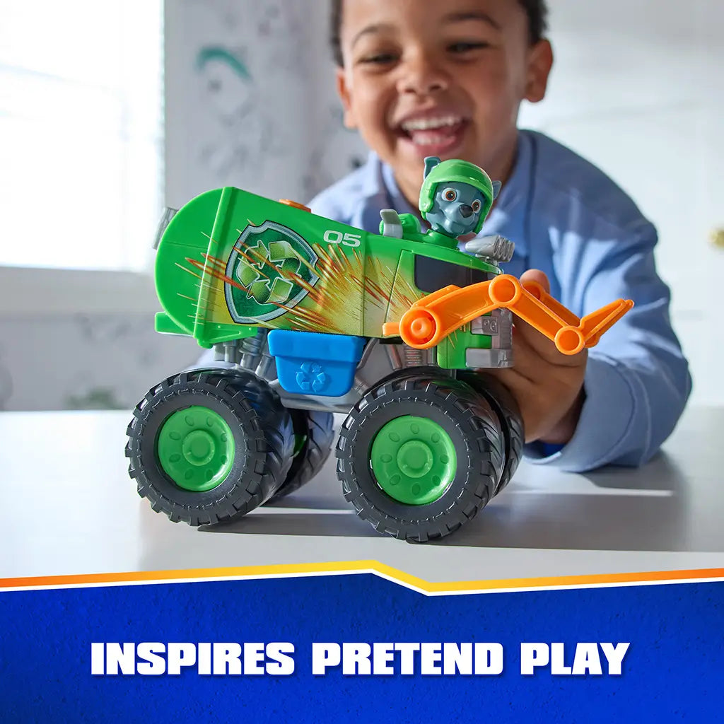 PAW Patrol Rocky recycle truck toy features bright green plastic body with textured details, large rugged wheels, and character figure, held by a child during imaginative pretend play in a bright indoor setting.
